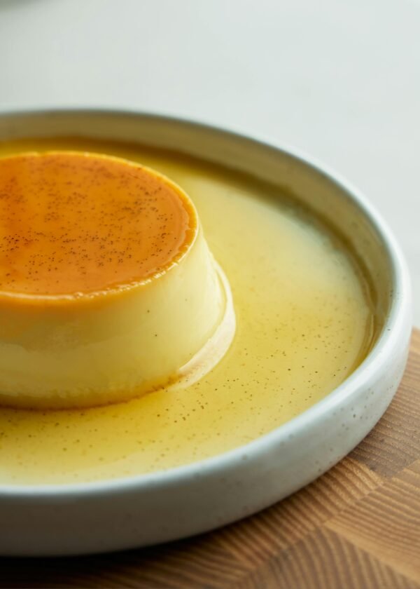 Close-up of a rich, creamy crème caramel dessert served on a plate, perfect for sweet indulgence.