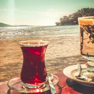 A tranquil beachfront setting with two glasses of tea against a picturesque ocean backdrop.